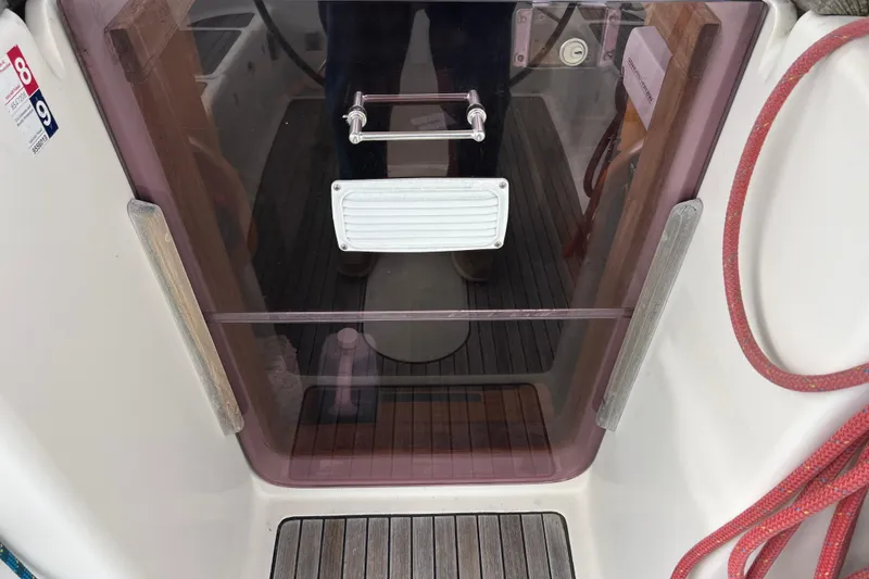 Slide: The Image of Cockpit entrance of 2007 Delphia 33 Sloop with wooden flooring and red rope. - 66