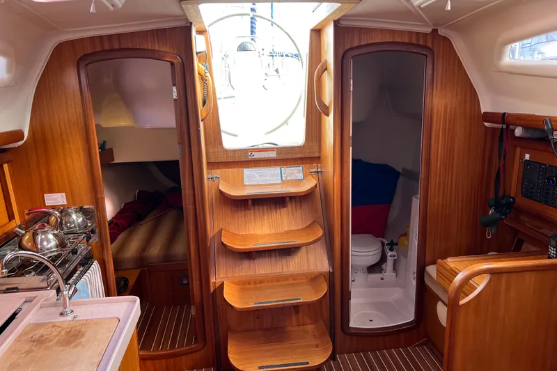 Slide: The Image of Interior of 2007 Delphia 33 Sloop, featuring wood finish, galley, and compact bathroom. - 67