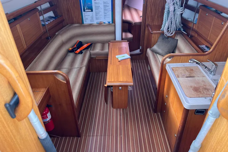 Slide: The Image of Interior of 2007 Delphia 33 Sloop, featuring wood finish, seating, and kitchenette. - 68