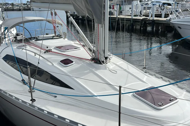 Slide: The Image of 2007 Delphia 33 Sloop docked at marina, showcasing sleek design and rigging. - 7