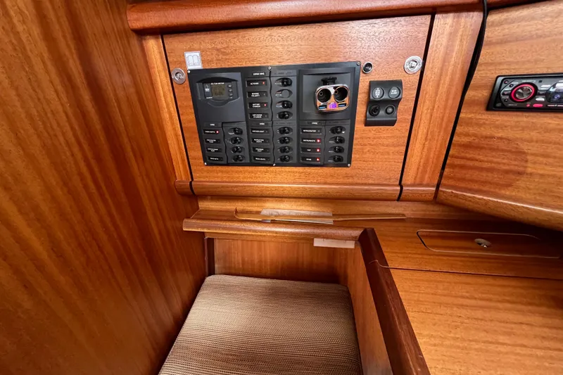 Slide: The Image of Control panel inside 2007 Delphia 33 Sloop, featuring wooden cabinetry and seating. - 74