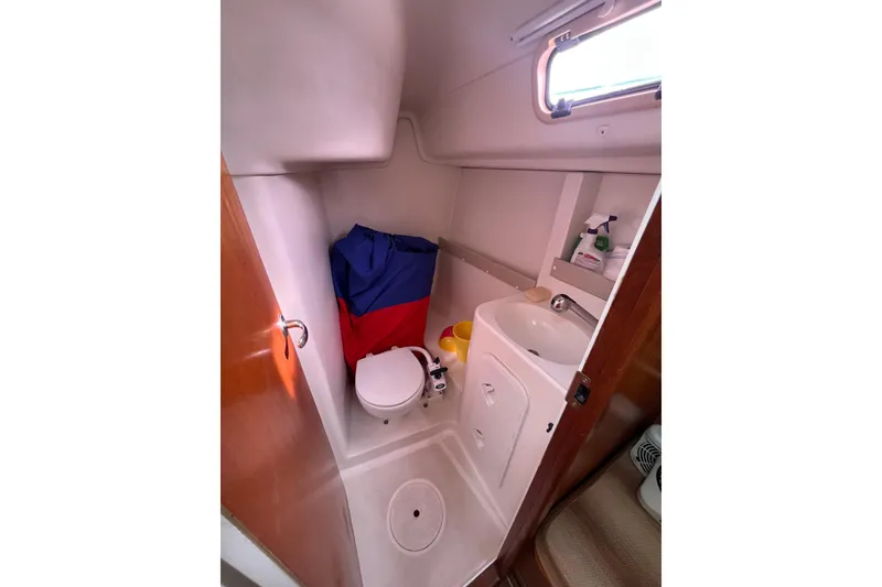 Slide: The Image of 2007 Delphia 33 Sloop bathroom with toilet, sink, and storage. - 77