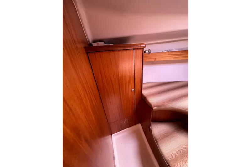 Slide: The Image of Wooden interior of 2007 Delphia 33 Sloop, featuring a cabinet and seating area. - 88