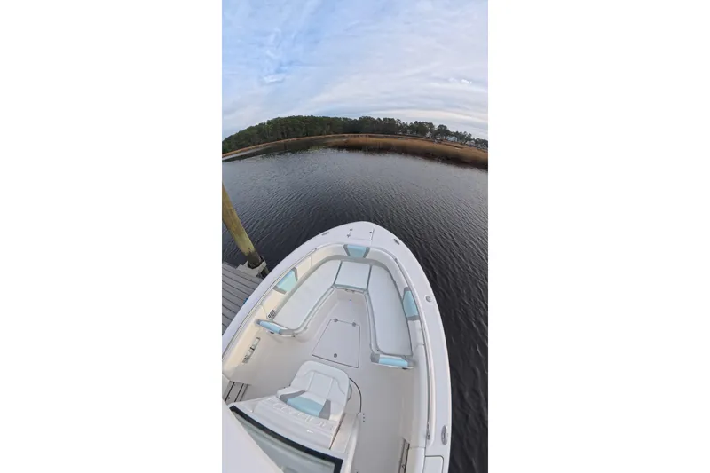 Slide: The Image of 2025 Robalo R250 Center Console with twin 150 engines docked on calm water. - 11