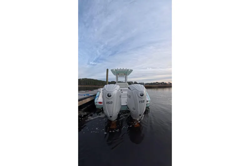 Slide: The Image of 2025 Robalo R250 Center Console boat with twin Yamaha engines on water. - 2
