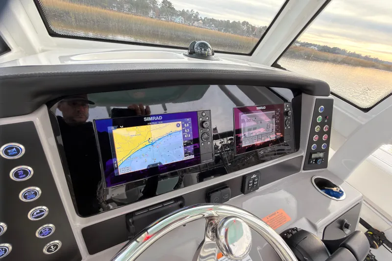 Slide: The Image of 2025 Robalo R250 Center Console boat on calm water under clear sky. - 4