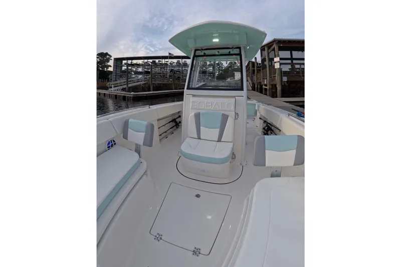 Slide: The Image of 2025 Robalo R250 Center Console boat docked at sunset, showcasing sleek design and spacious deck. - 7