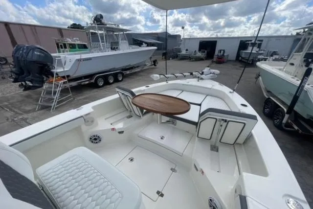 Slide: The Image of 2026 Pathfinder 2600 TRS boat with seating and table, docked in a marina. - 11