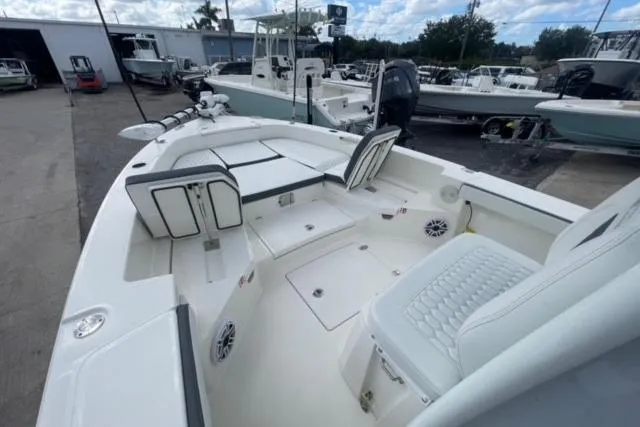 Slide: The Image of 2026 Pathfinder 2600 TRS boat interior with seating and storage, docked at a marina. - 18