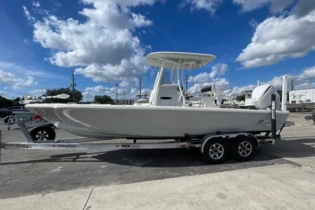 Slide: The Image of 2026 Pathfinder 2600 TRS boat on trailer under a partly cloudy sky. - 2