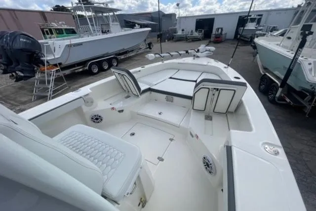 Slide: The Image of 2026 Pathfinder 2600 TRS boat interior with seating and storage, docked outdoors. - 20