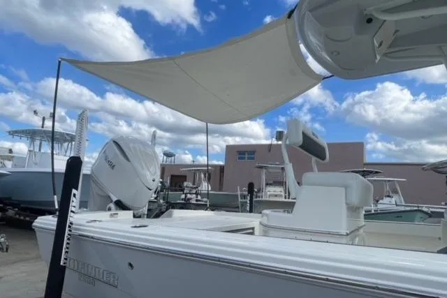 Slide: The Image of 2026 Pathfinder 2600 TRS boat with canopy, docked under a blue sky with clouds. - 6