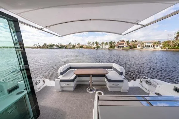 Slide: The Image of 2018 Cruisers Yachts 50 Cantius luxury deck with seating, table, and waterfront view. - 9