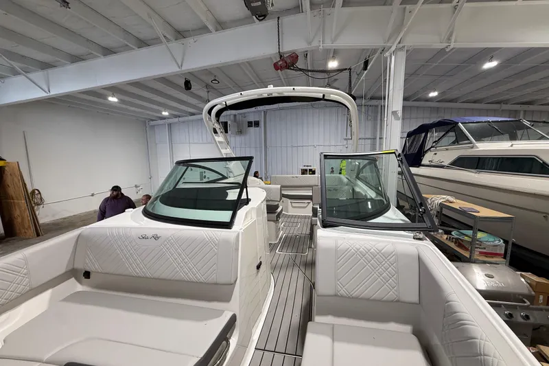 Slide: The Image of 2026 Sea Ray SDX 270 boat interior in a showroom, featuring luxurious seating and modern design. - 20