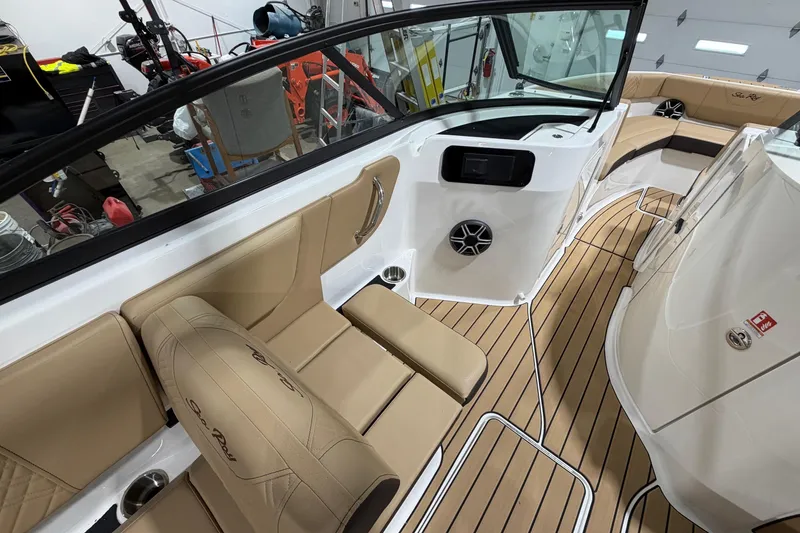 Slide: The Image of 2026 Sea Ray SDX 250 boat interior with tan seating and wood-style flooring. - 11