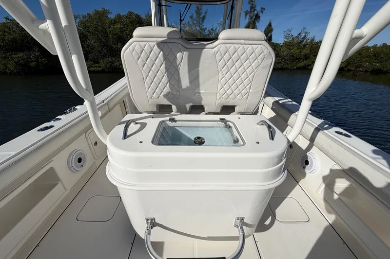 Slide: The Image of 2025 World Cat 295 CC boat interior with cushioned seating and storage compartment. - 13