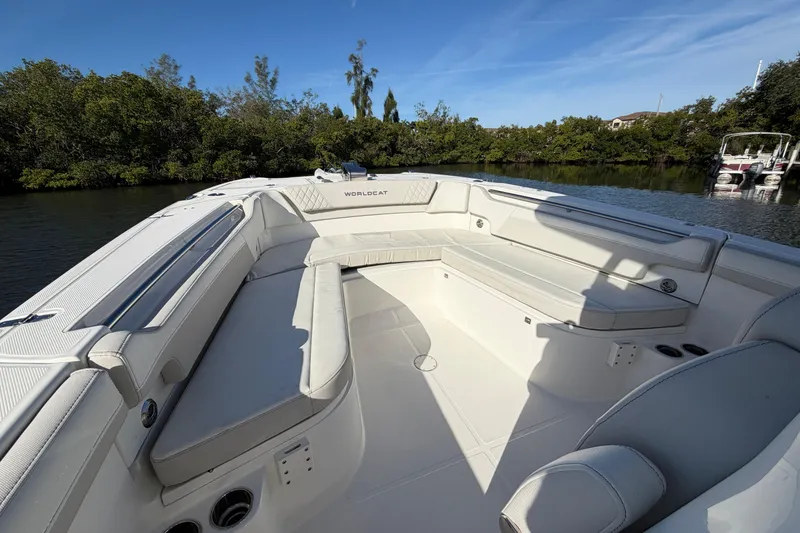 Slide: The Image of 2025 World Cat 295 CC boat interior with spacious seating, surrounded by lush greenery. - 9