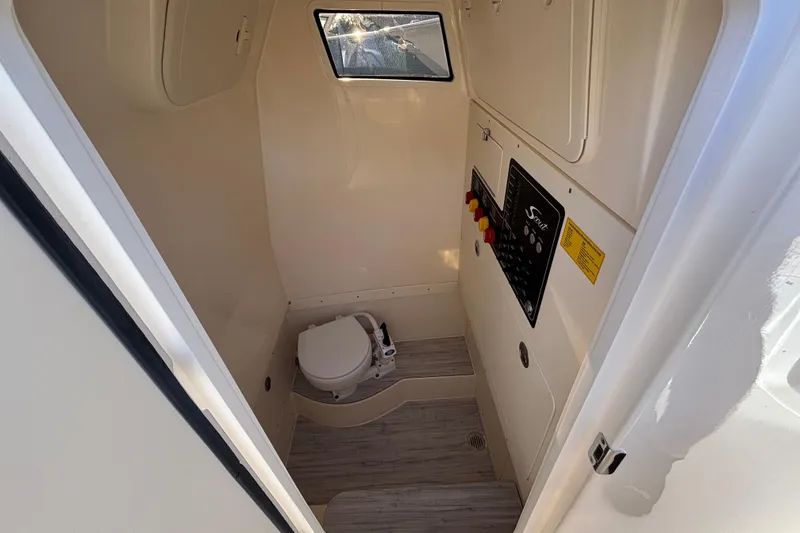 Slide: The Image of 2026 Scout 260 LXF boat interior with compact marine toilet and control panel. - 16