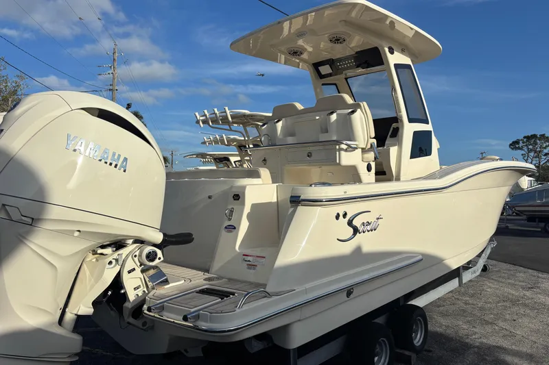 Slide: The Image of 2026 Scout 260 LXF boat with Yamaha engine, parked on trailer under clear sky. - 2