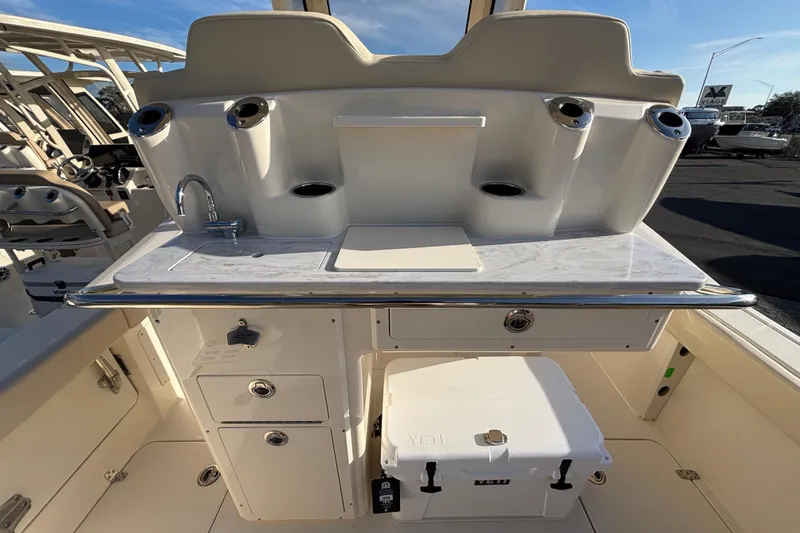 Slide: The Image of 2026 Scout 260 LXF boat interior with sink, storage, and Yeti cooler. - 6