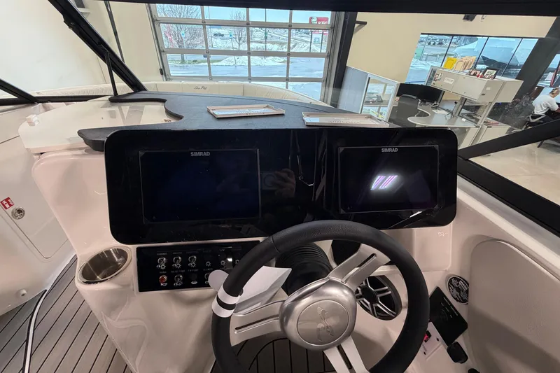 Slide: The Image of 2026 Sea Ray SDX 230 boat dashboard with dual Simrad displays and steering wheel. - 11