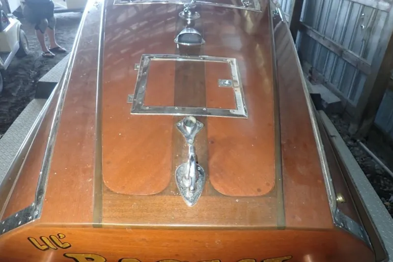 Slide: The Image of 2004 Mays Craft 25 Gentleman's Racer with polished wood finish in a storage area. - 11