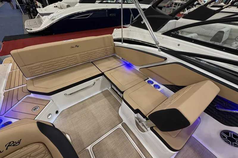Slide: The Image of 2026 Sea Ray SPX 210 boat interior with tan seating and blue LED lighting. - 10