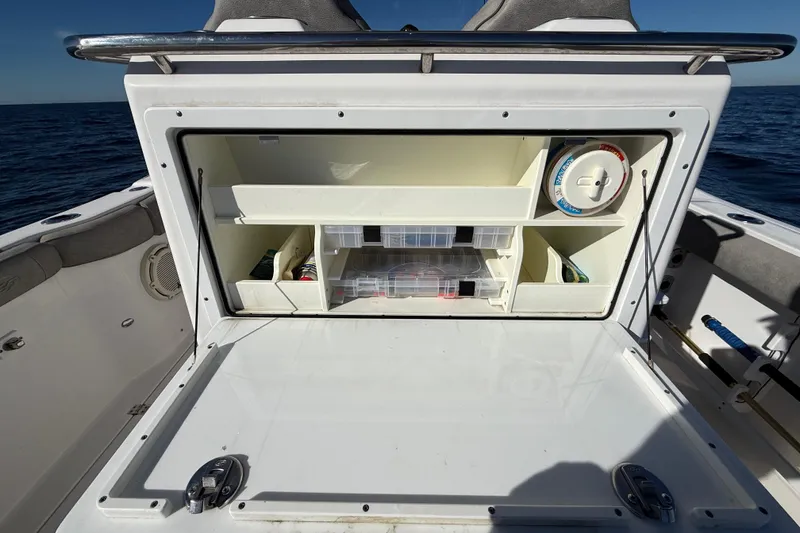 Slide: The Image of 2021 Sea Fox 288 Commander boat storage compartment with organized shelves and containers. - 11