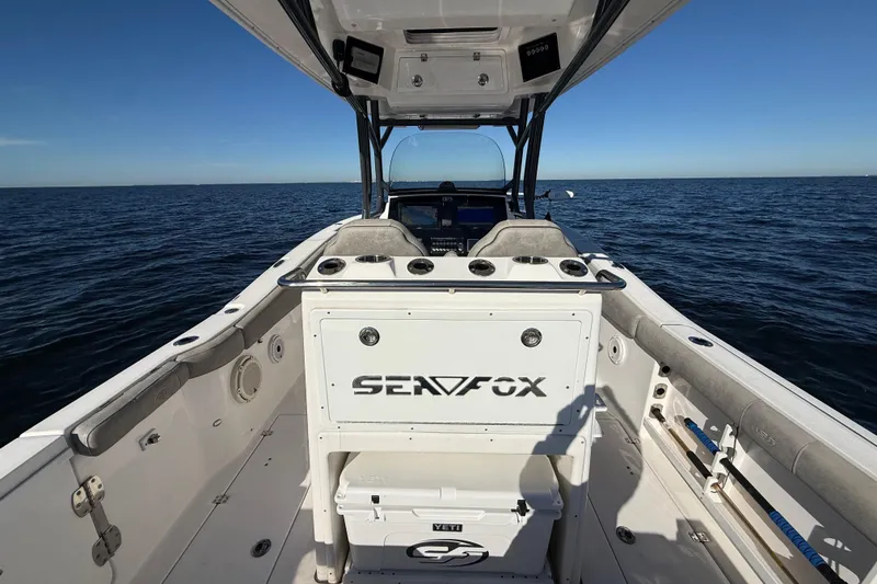 Slide: The Image of 2021 Sea Fox 288 Commander boat interior on open water, showcasing seating and storage. - 12