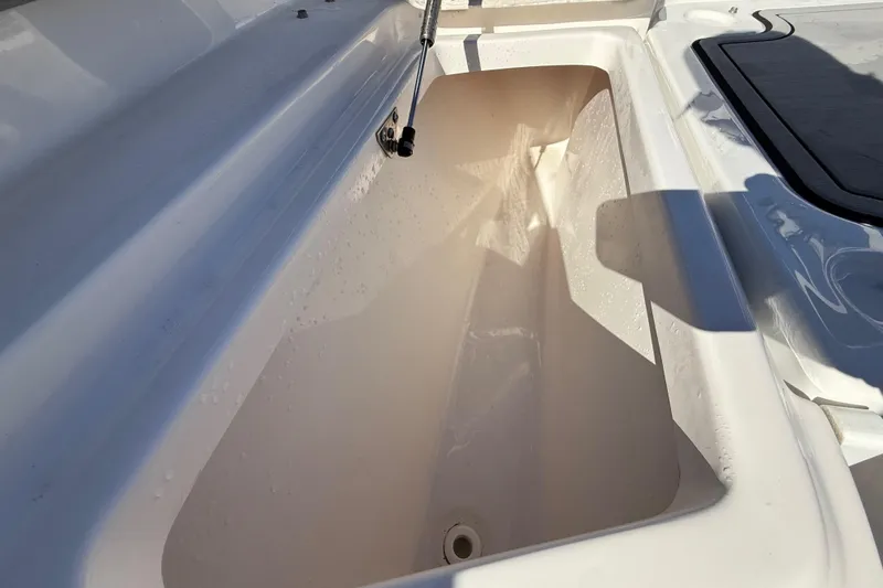 Slide: The Image of 2021 Sea Fox 288 Commander storage compartment, open and empty, with sunlight casting shadows. - 53