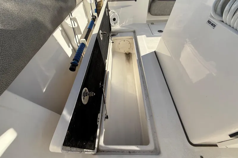 Slide: The Image of 2021 Sea Fox 288 Commander boat storage compartment with open hatch and fresh water hose. - 81