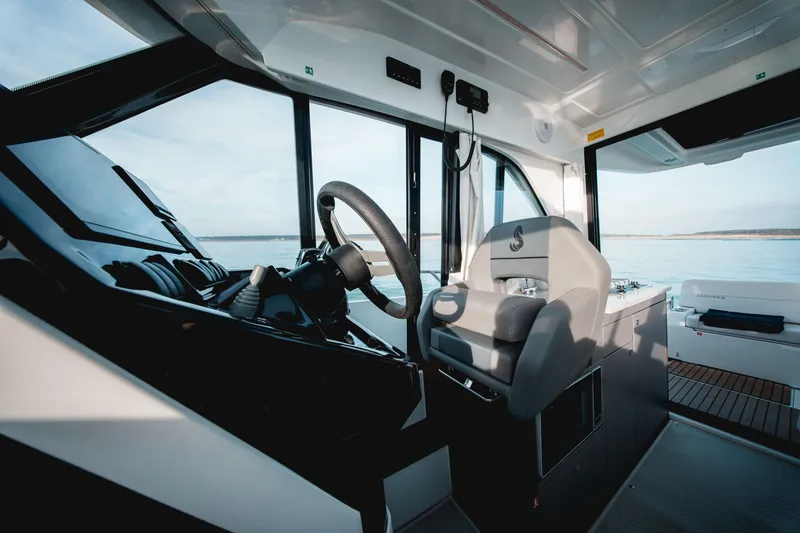 Slide: The Image of Interior of 2026 Beneteau Antares 9 V2 boat, featuring modern helm and seating. - 23