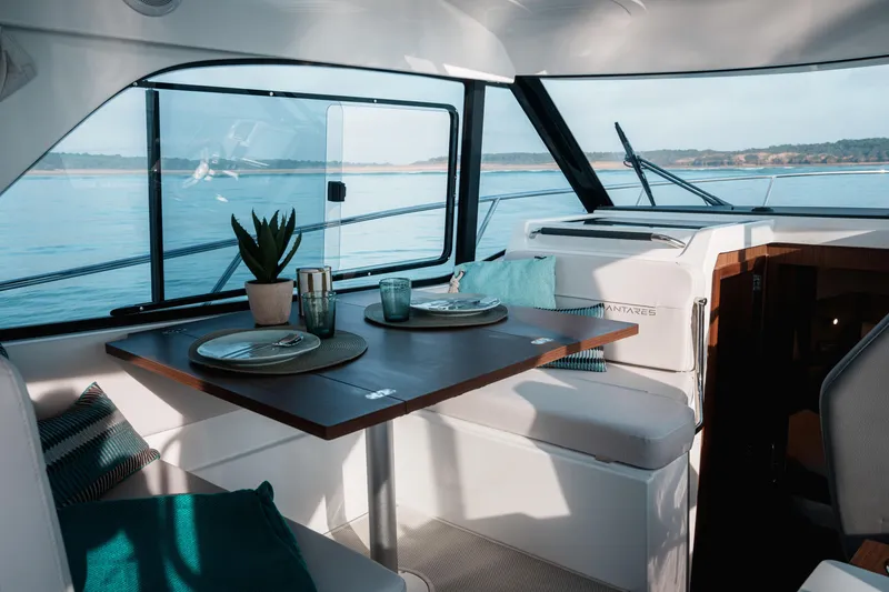 Slide: The Image of Interior of 2026 Beneteau Antares 9 V2 yacht with elegant dining setup and scenic view. - 18