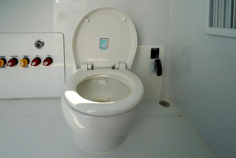 Slide: The Image of Toilet on 2026 Invincible 40 Catamaran with control panel and key. - 40
