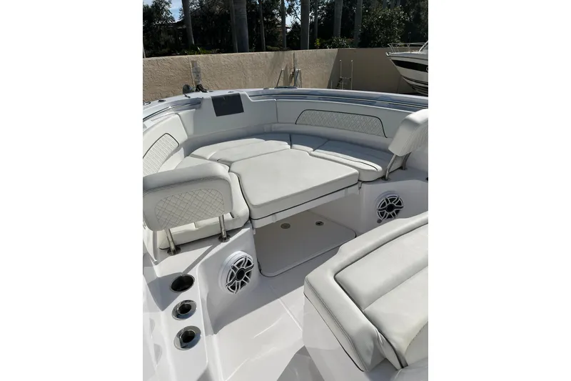 Slide: The Image of 2023 Bertram 28 CC boat interior with cushioned seating and built-in speakers. - 10