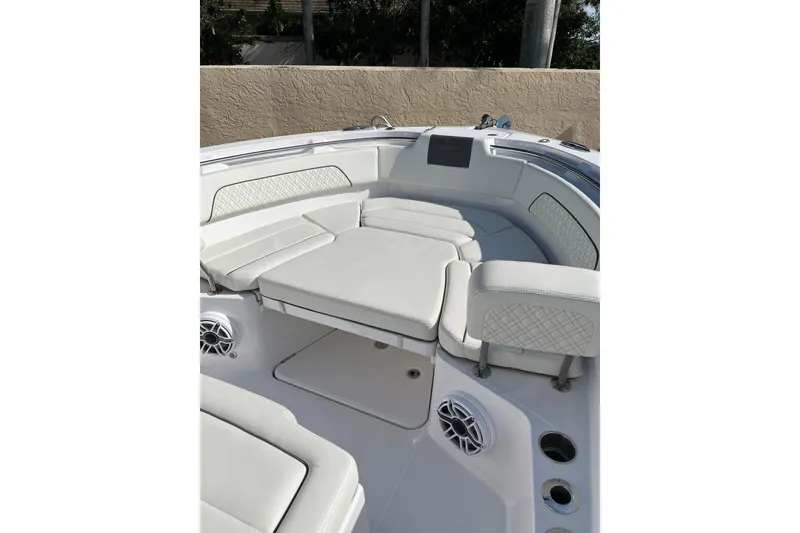 Slide: The Image of 2023 Bertram 28 CC boat interior with white cushioned seating and speakers. - 11