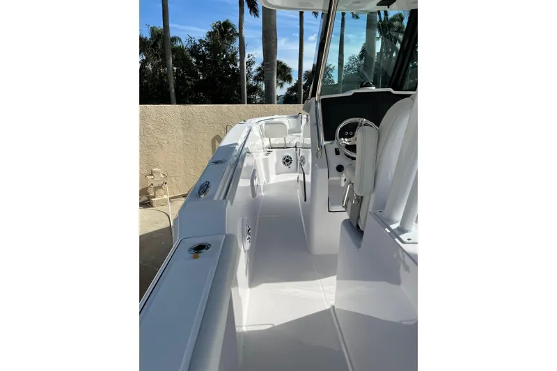Slide: The Image of 2023 Bertram 28 CC boat interior with sleek white design and modern steering console. - 13