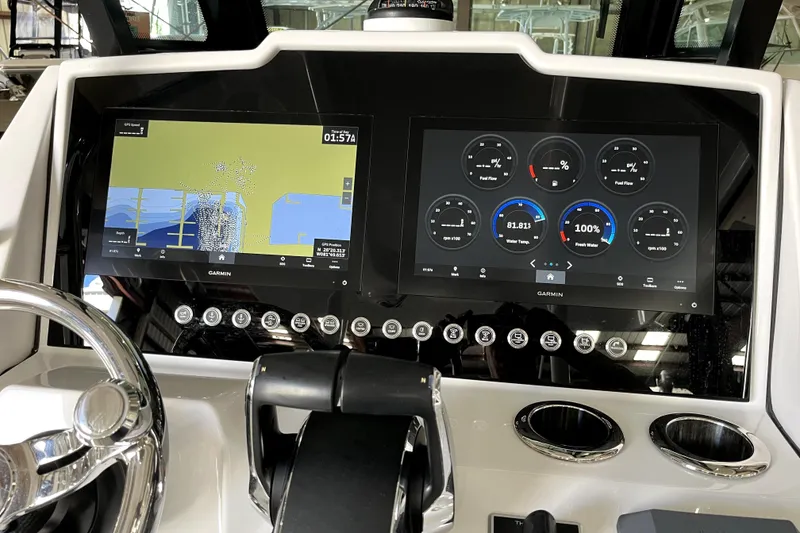 Slide: The Image of 2023 Bertram 28 CC boat dashboard with Garmin navigation and control screens. - 3