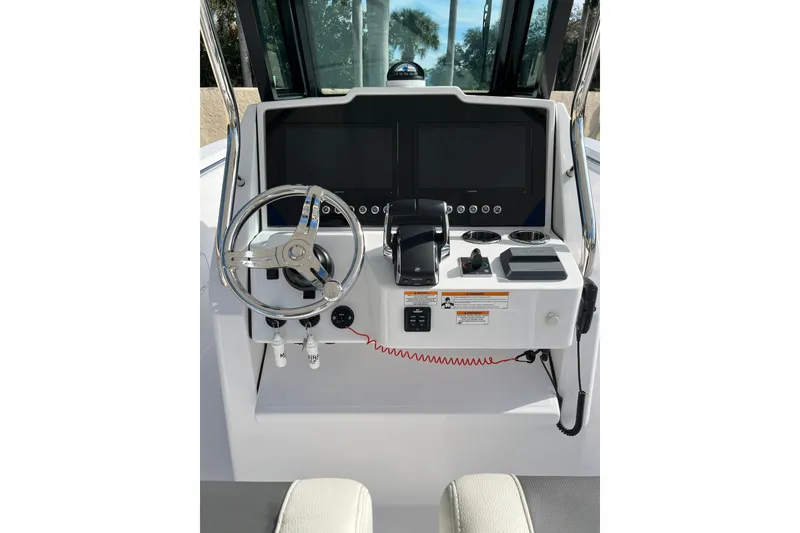 Slide: The Image of 2023 Bertram 28 CC boat dashboard with steering wheel and control panel. - 7