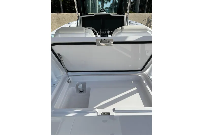 Slide: The Image of 2023 Bertram 28 CC boat storage compartment with open lid, showcasing interior space. - 8