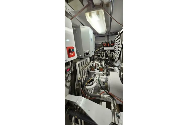 Slide: The Image of Engine room of 1969 Derecktor 68 Hunt Motor Yacht, showcasing complex piping and machinery. - 23
