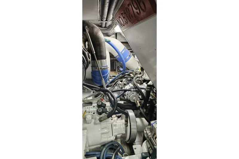 Slide: The Image of Engine room of 1969 Derecktor 68 Hunt Motor Yacht, featuring complex machinery and hoses. - 25
