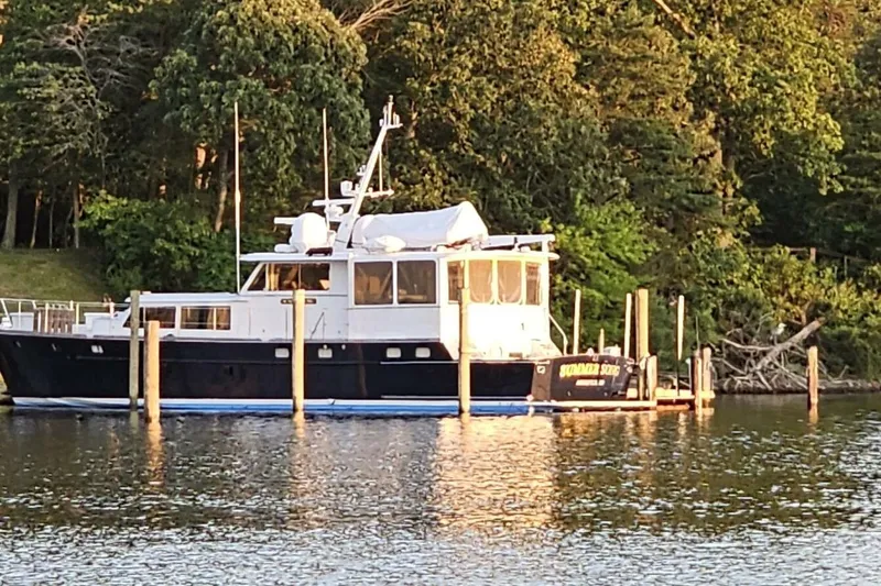 Slide: The Image of 1969 Derecktor 68 Hunt Motor Yacht docked by lush green trees. - 3
