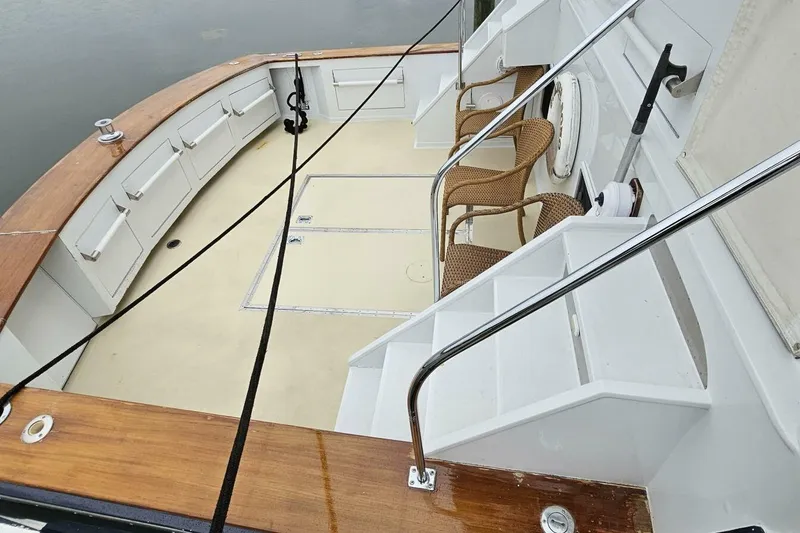 Slide: The Image of 1969 Derecktor 68 Hunt Motor Yacht deck with seating and wooden accents. - 5