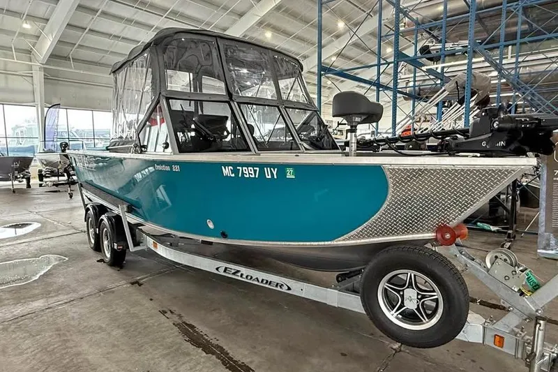 Slide: The Image of 2024 Hewescraft 221 Evolution boat on trailer in indoor showroom. - 1