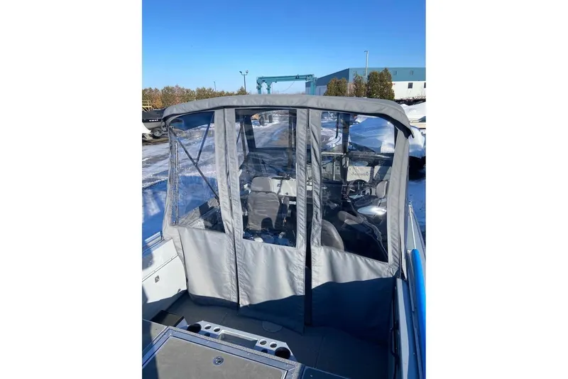 Slide: The Image of 2024 Hewescraft 221 Evolution boat with enclosed cockpit, parked in snowy outdoor setting. - 10