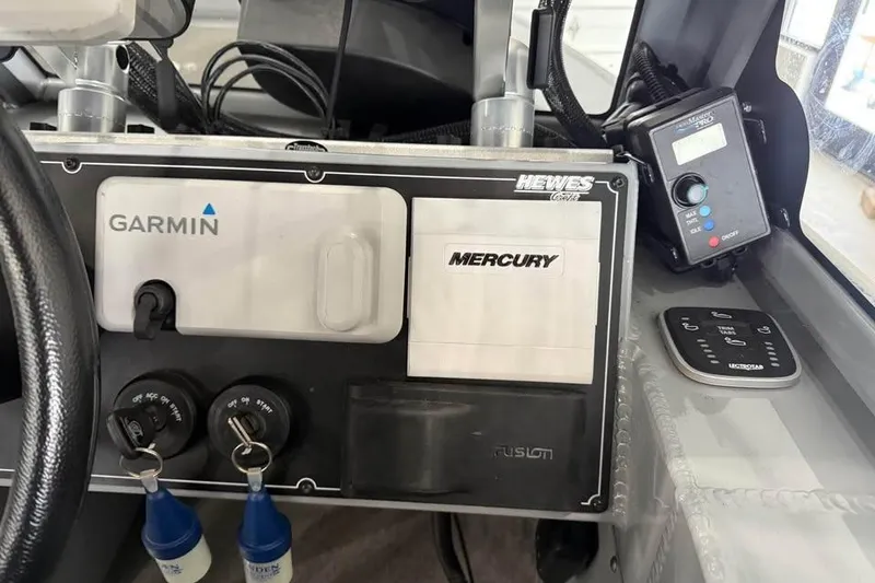 Slide: The Image of 2024 Hewescraft 221 Evolution dashboard featuring Garmin and Mercury controls. - 16