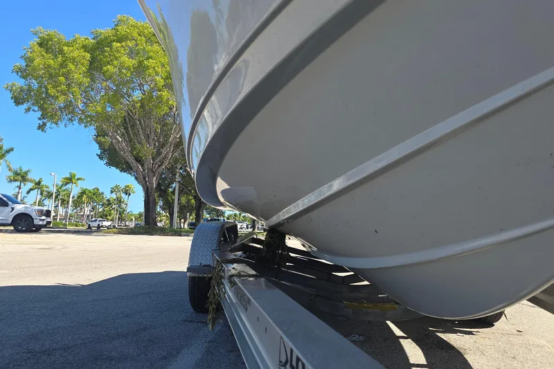 Slide: The Image of 2018 Sportsman Heritage 241 Center Console boat on trailer, sunny day, palm trees in background. - 19