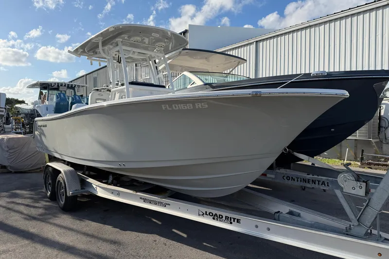 Slide: The Image of 2018 Sportsman Heritage 241 Center Console boat on trailer, parked outdoors. - 2