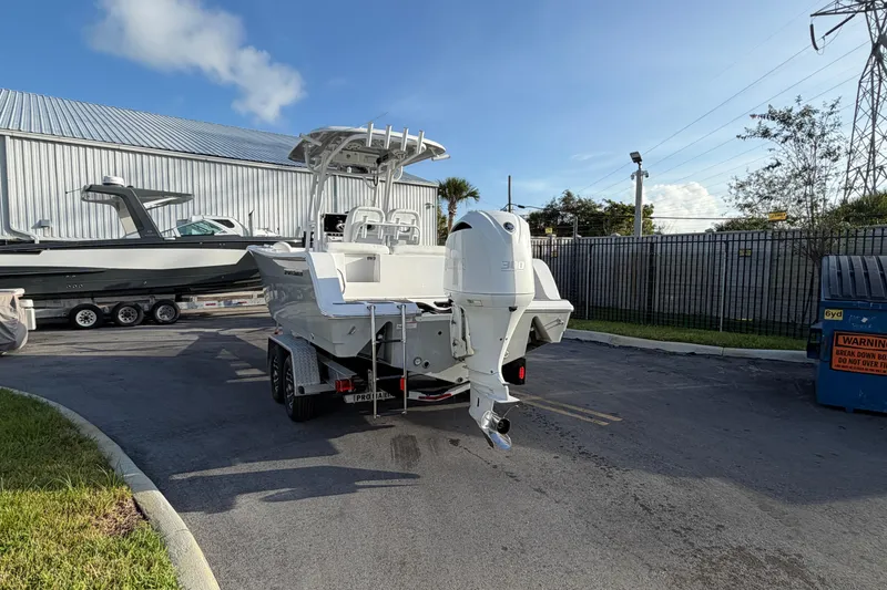 Slide: The Image of 2018 Sportsman Heritage 241 Center Console boat on trailer, parked outdoors. - 4